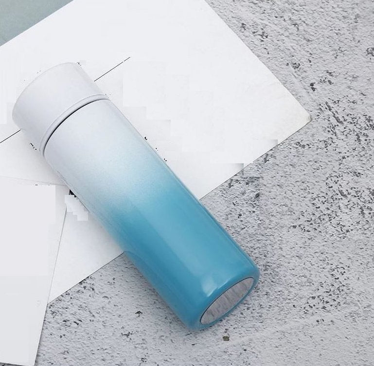 Blue and white gradient stainless steel vacuum flask with temperature display, perfect for travel and hot or cold beverages. Compact and stylish design.