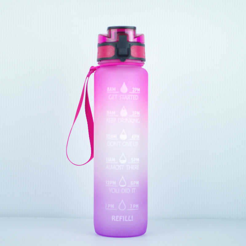 Pink gradient 1000ml water bottle with time markers, leakproof lid, and wrist strap for convenient hydration.